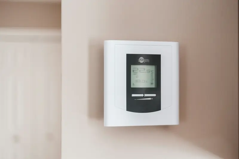 Digital thermostat mounted on a home wall